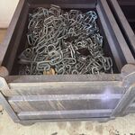 Industriële partij met stalen bakken, kettingen en hijsmateriaal